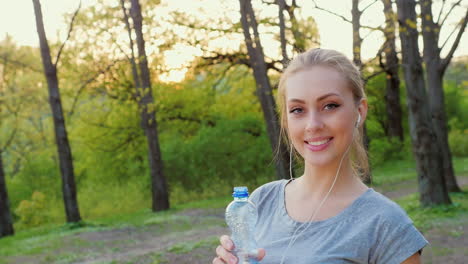 Attraktive-Frau-Trinkt-Wasser-Aus-Einer-Flasche-Im-Park